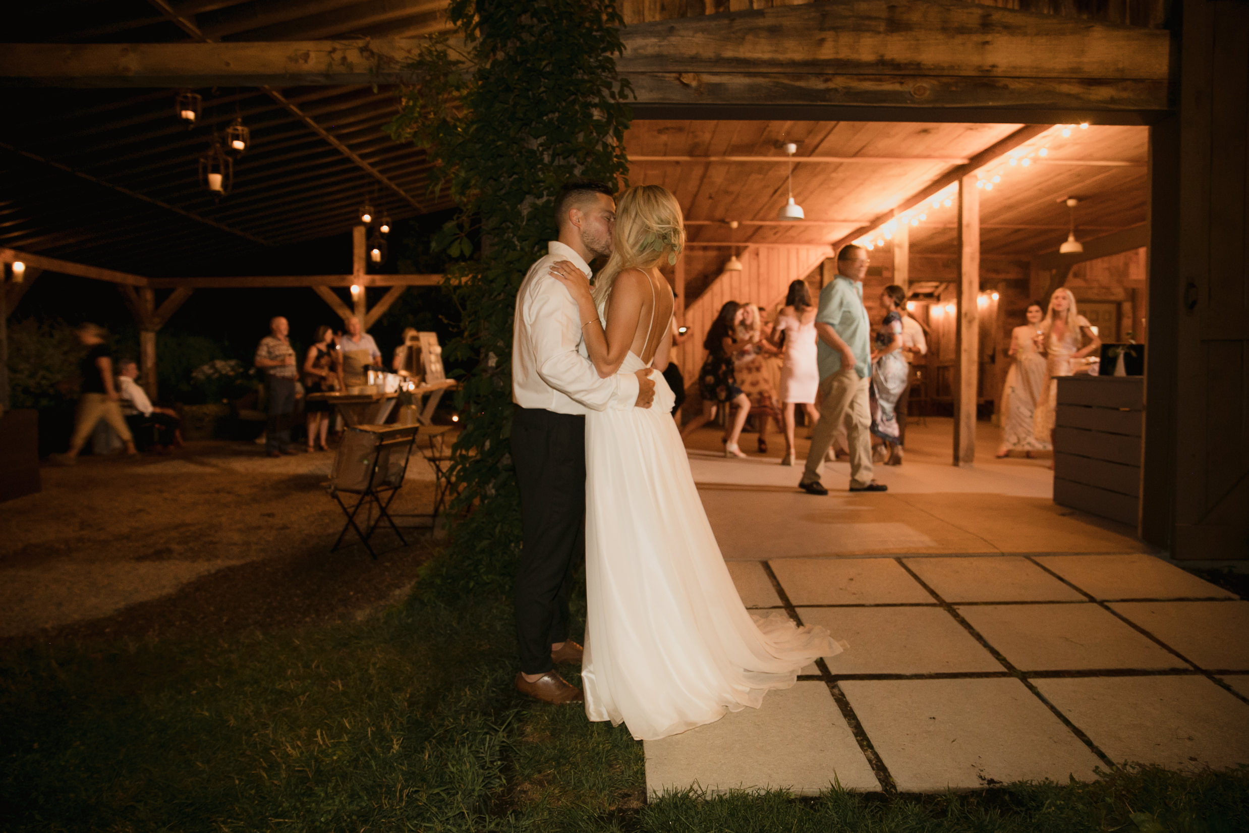 Wedding photo bride and groom reception candid kiss outside dance floor