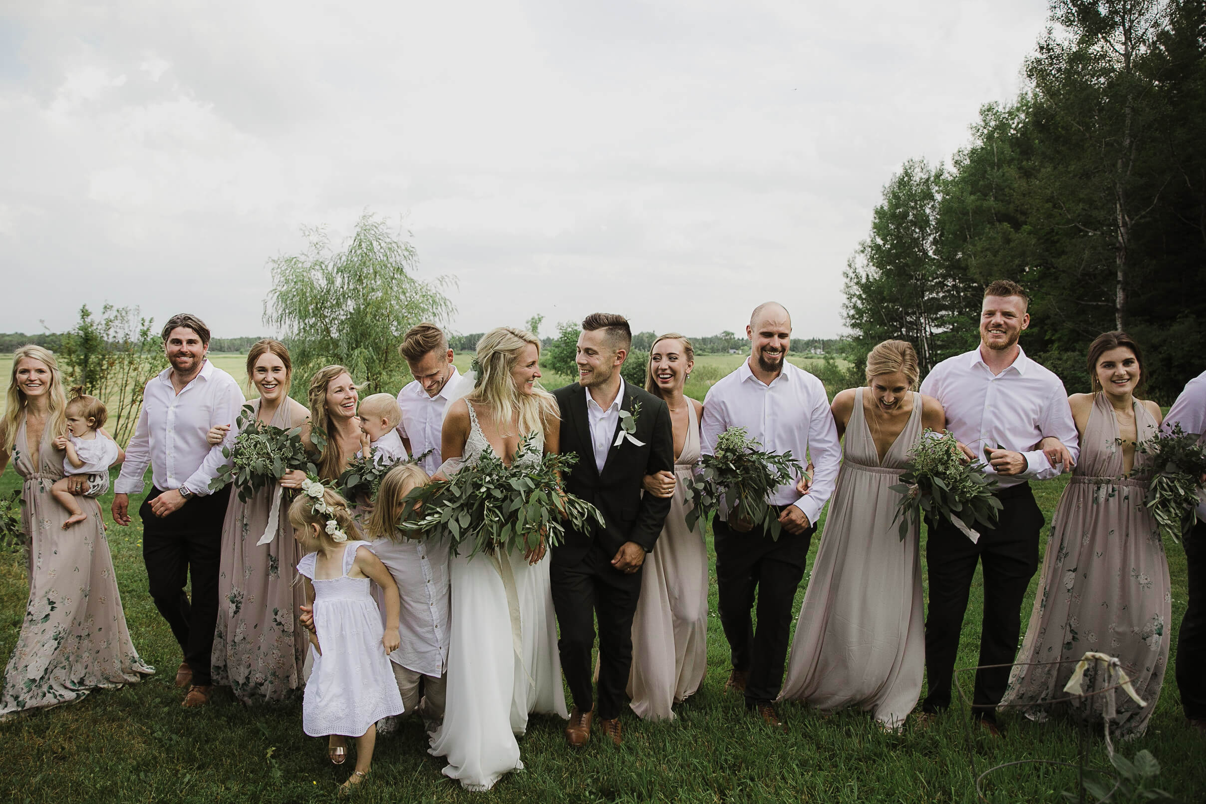 Wedding photo bridal party walking eucalyptus bouquets neutral tones bridesmaid dresses 