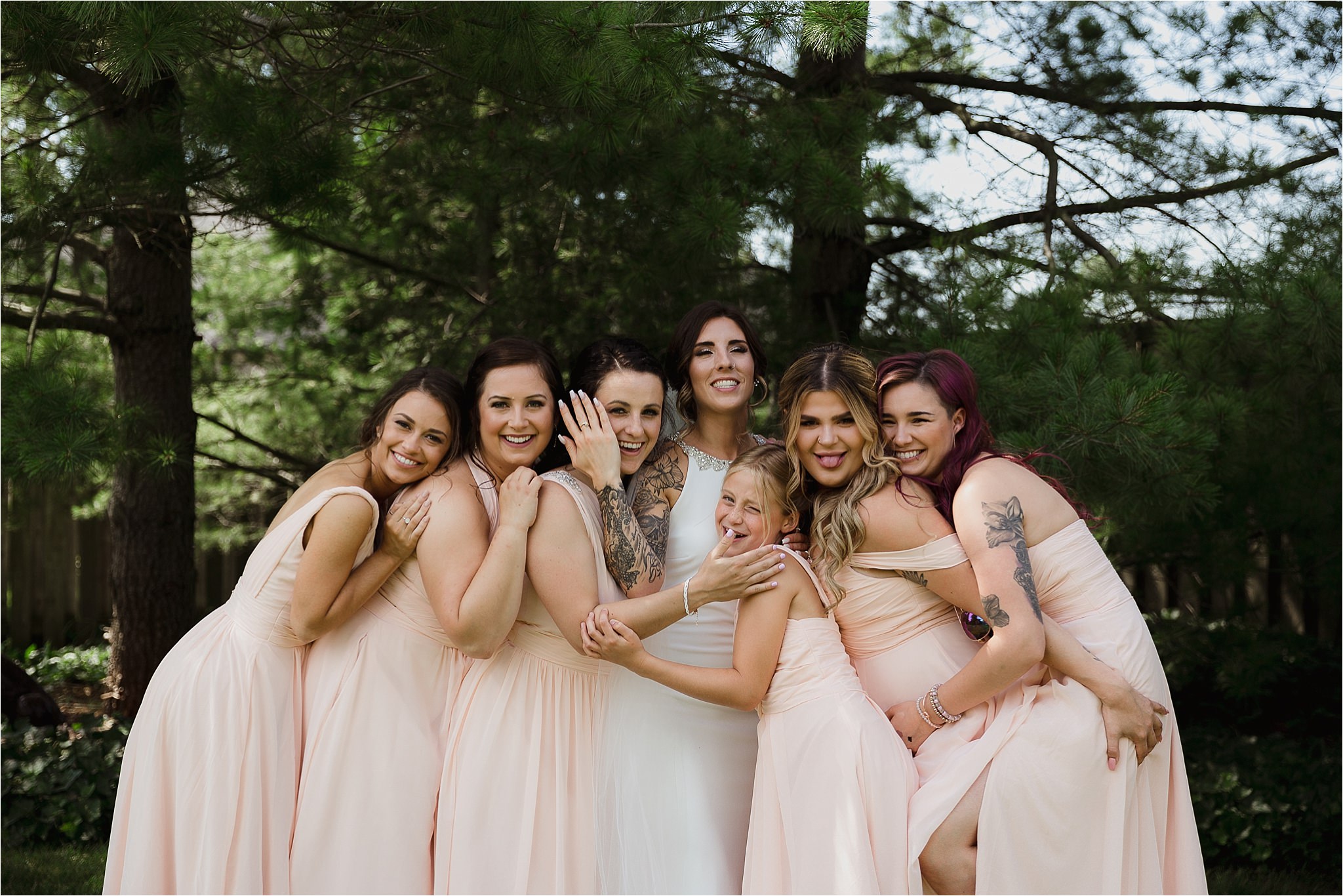 Bride with bridesmaids outside in long blush dresses