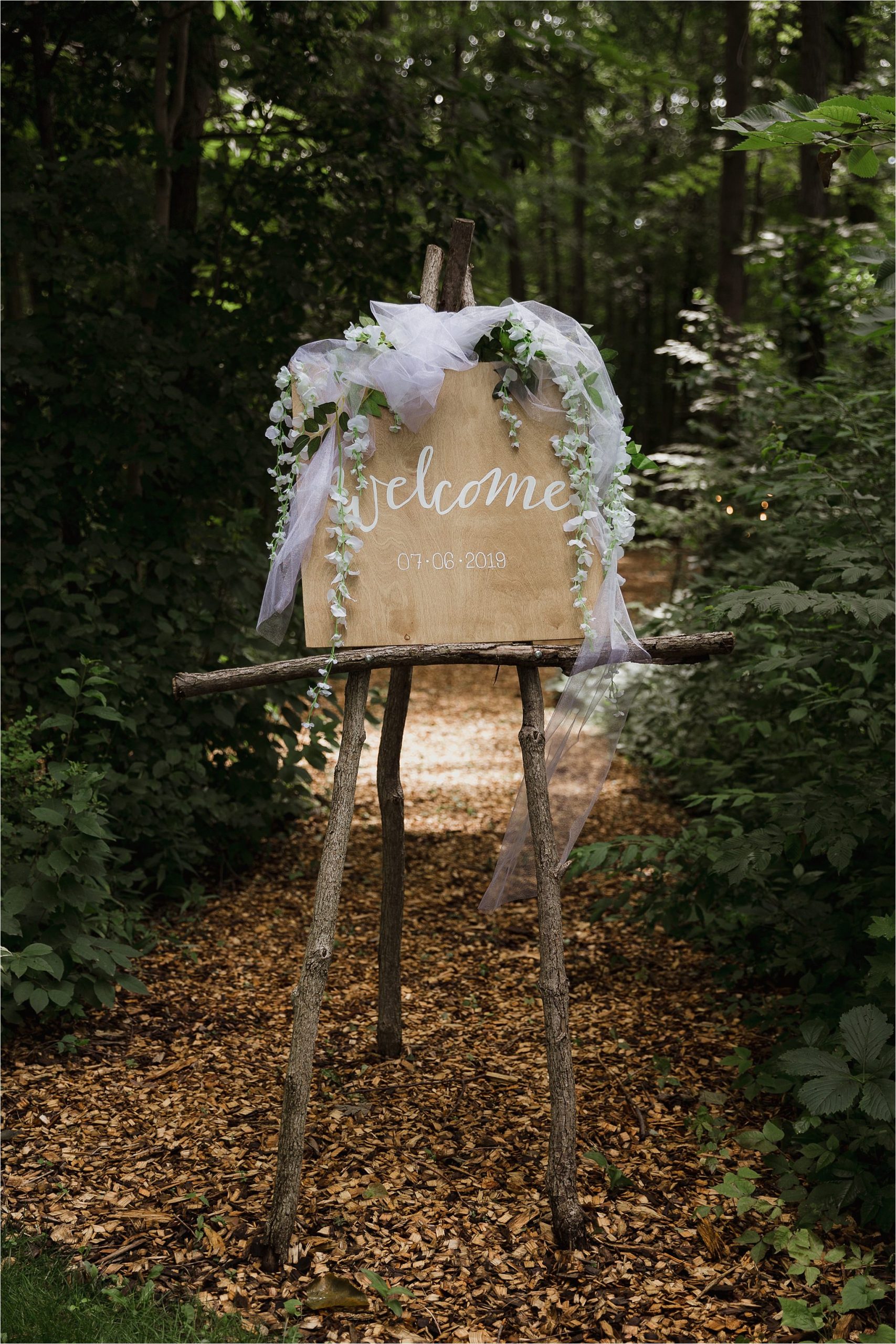 The Clearing wedding venue welcome ceremony sign green floral and tulle