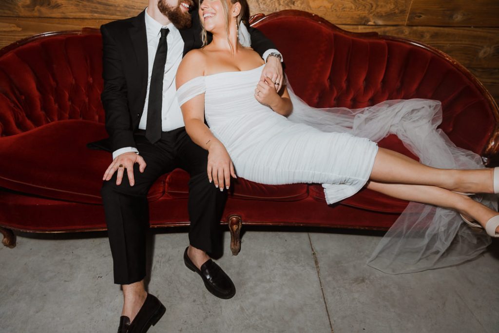 bride and groom on red sofa flash Modern wedding day at Cranberry Creek Gardens by Sonia V Photography