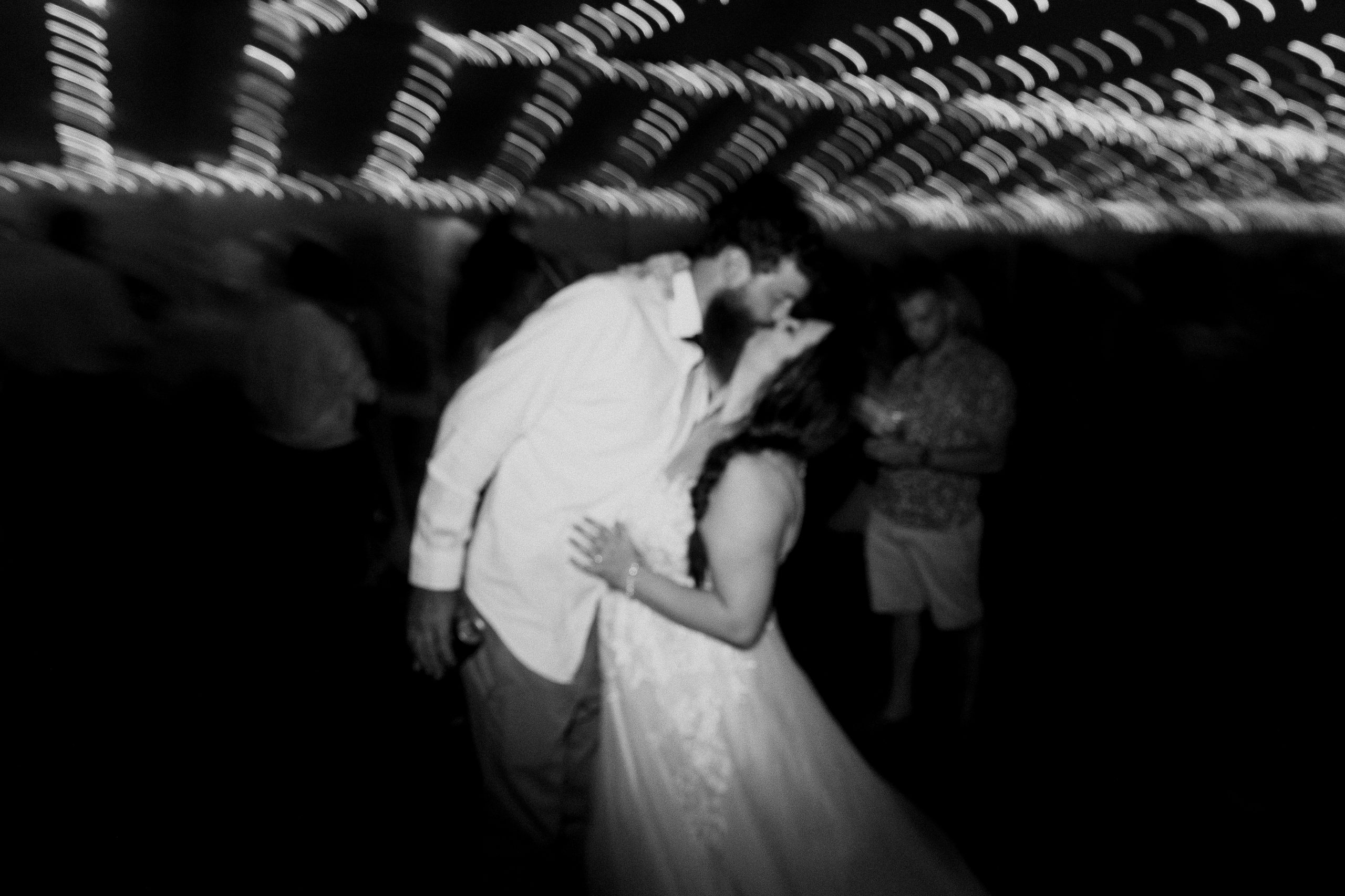 Bride and groom kissing black and white on the dance floor under twinkle lights - Sonia V Photo -Documentary Style Candid Photographer - Ottawa Ontario Kemptville Destination Photographer - Authentic Colour Photography - Wedding Photographer - Branding Photographer - Small Business Headshots - Engagement Photos - Family Portraits - Lifestyle