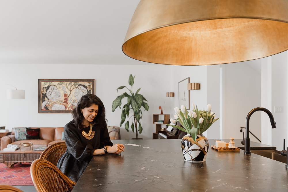 woman sitting at kitchen with large brass fixture home in the Glebe Ottawa Ontario Studio-Kahaani-Ottawa-interior-design-inspiration-ideas-brand-photos-by-Sonia-V-Photography