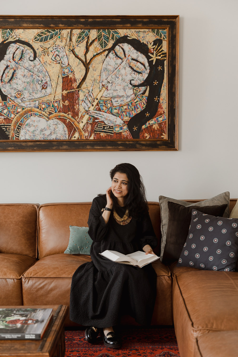 Woman sitting on couch reading Living room with arch lamp leather couch persian rug Indian inspired home in the Glebe Ottawa Ontario Studio-Kahaani-Ottawa-interior-design-inspiration-ideas-brand-photos-by-Sonia-V-Photography