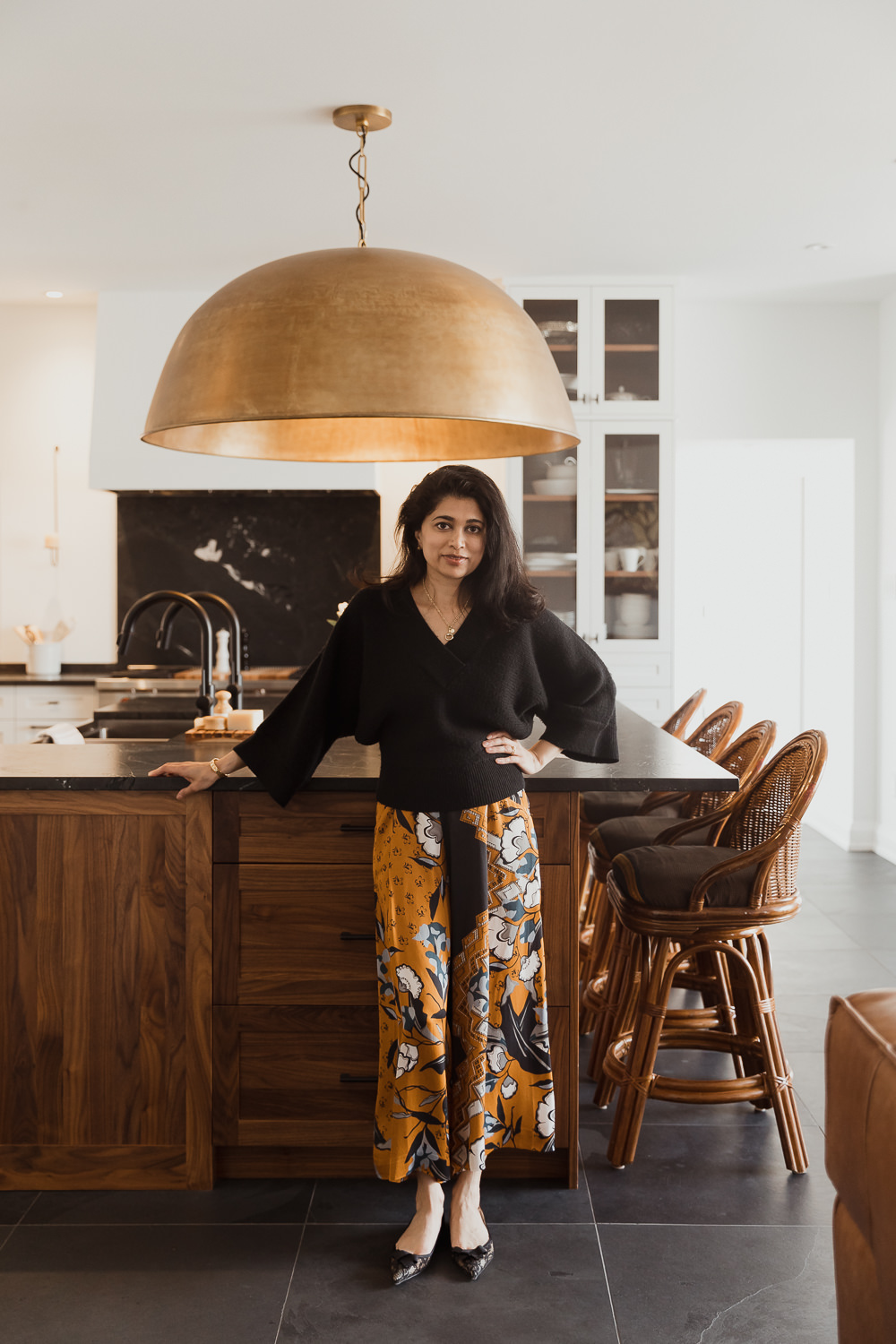 woman walking through kitchen with large brass fixture home in the Glebe Ottawa Ontario Studio-Kahaani-Ottawa-interior-design-inspiration-ideas-brand-photos-by-Sonia-V-Photography
