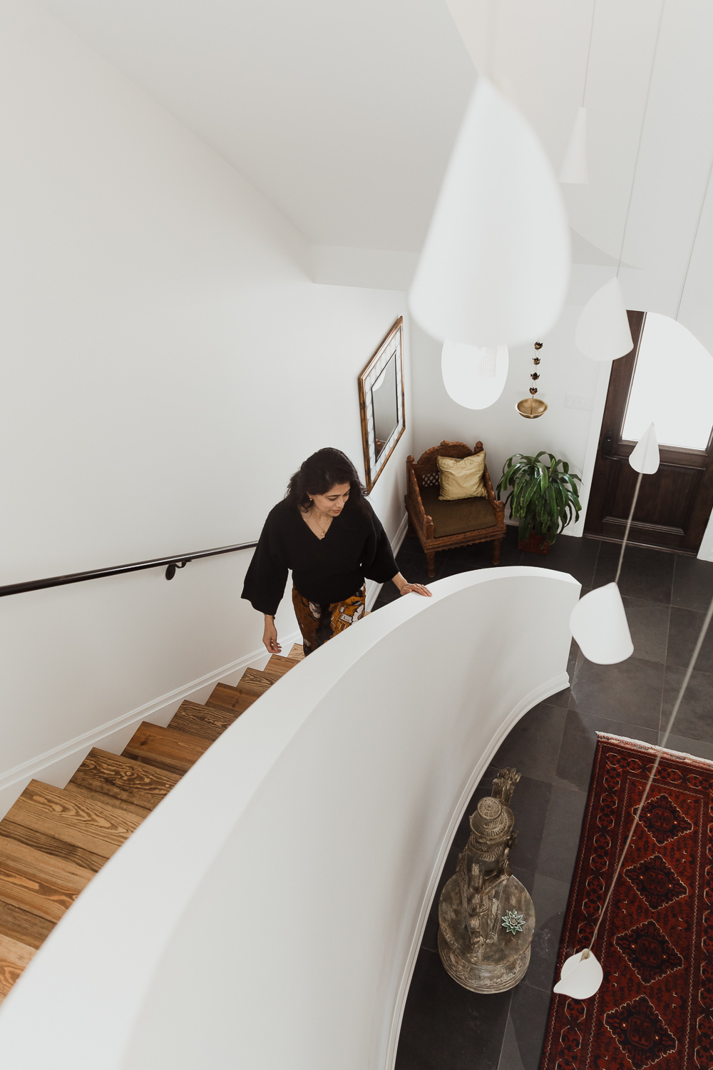 woman walking up curved stairs in Indian inspired home in the Glebe Ottawa Ontario Studio-Kahaani-Ottawa-interior-design-inspiration-ideas-brand-photos-by-Sonia-V-Photography