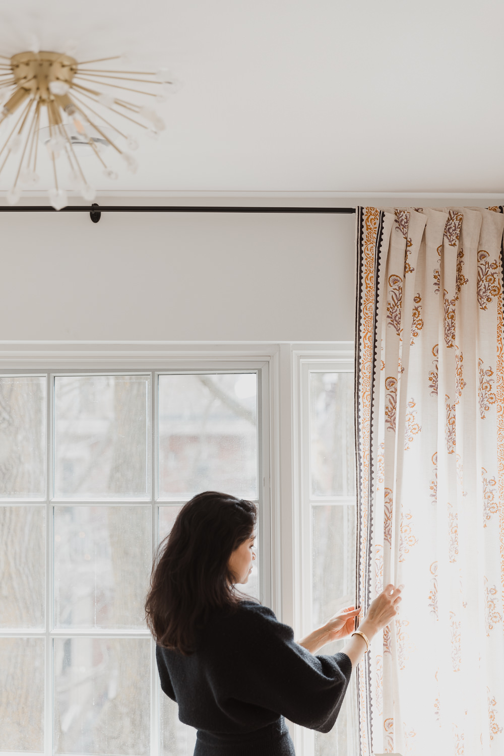 woman holding curtains in Home office design curtains black french doors white desk Indian inspired home in the Glebe Ottawa Ontario Studio-Kahaani-Ottawa-interior-design-inspiration-ideas-brand-photos-by-Sonia-V-Photography
