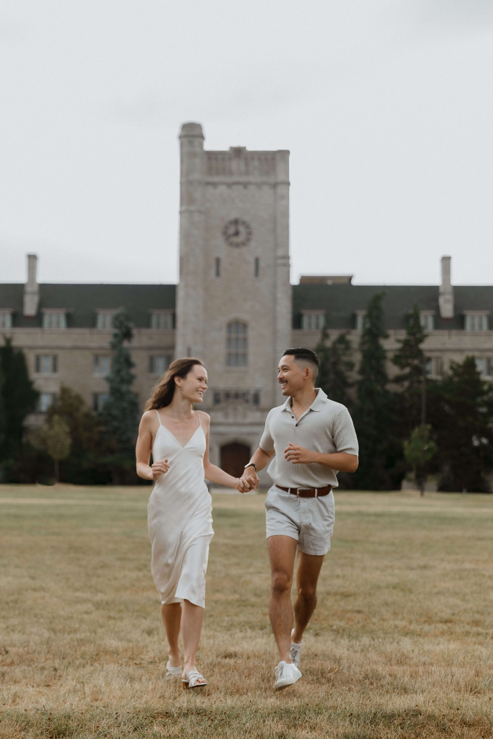 Engagement photos at Guelph University outside the old buildings | Sonia V Photography couple running through university field