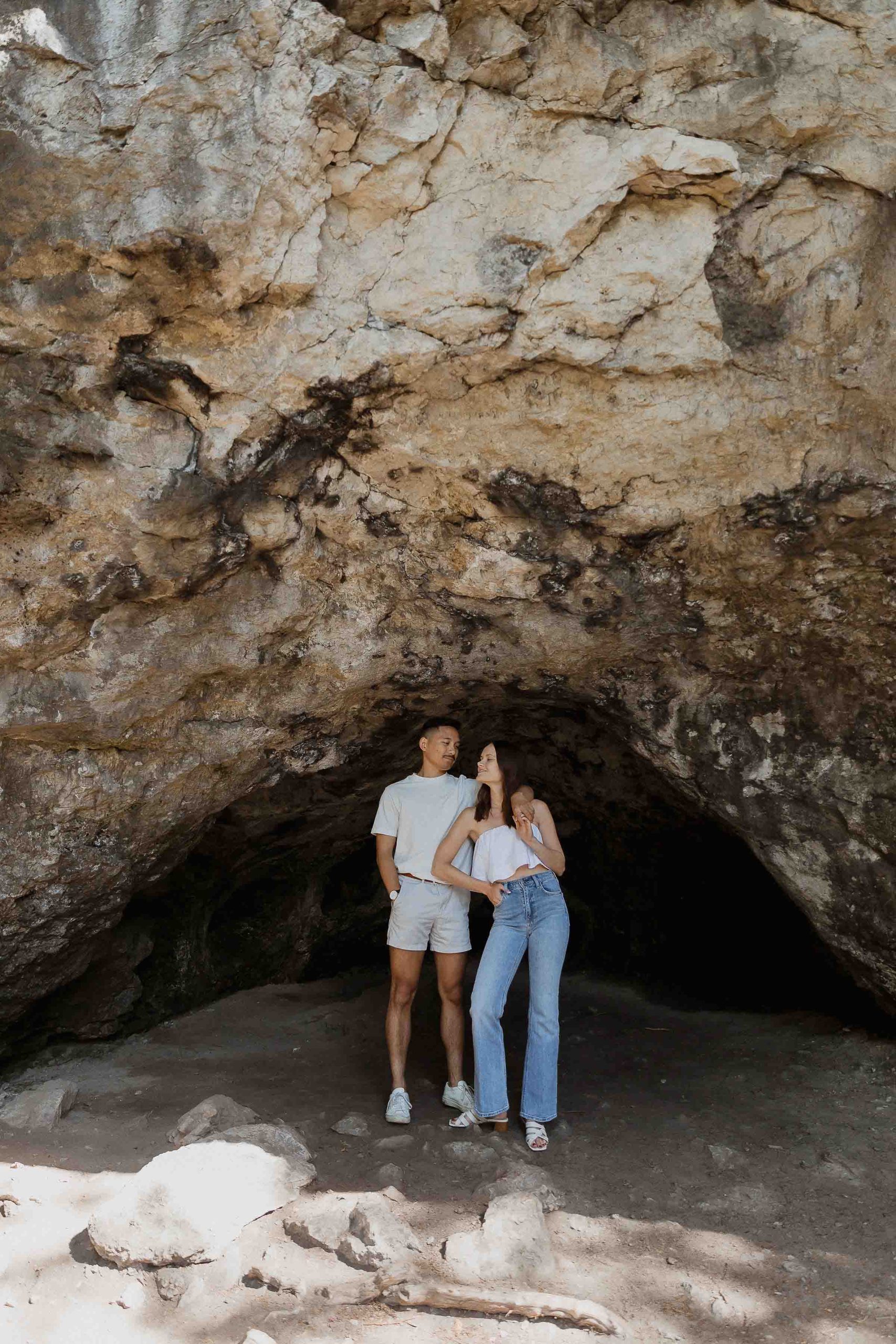 Engagement photos at Guelph conservation area, guelph lake, harris mill ruins, Sonia V Photography couple standing under rocks cave