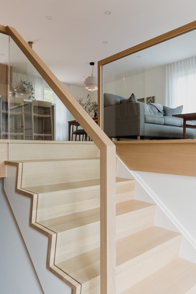 Unique all glass entry staircase railing by VI Design Ottawa and Murdock Construction and wood slatted feature wall
