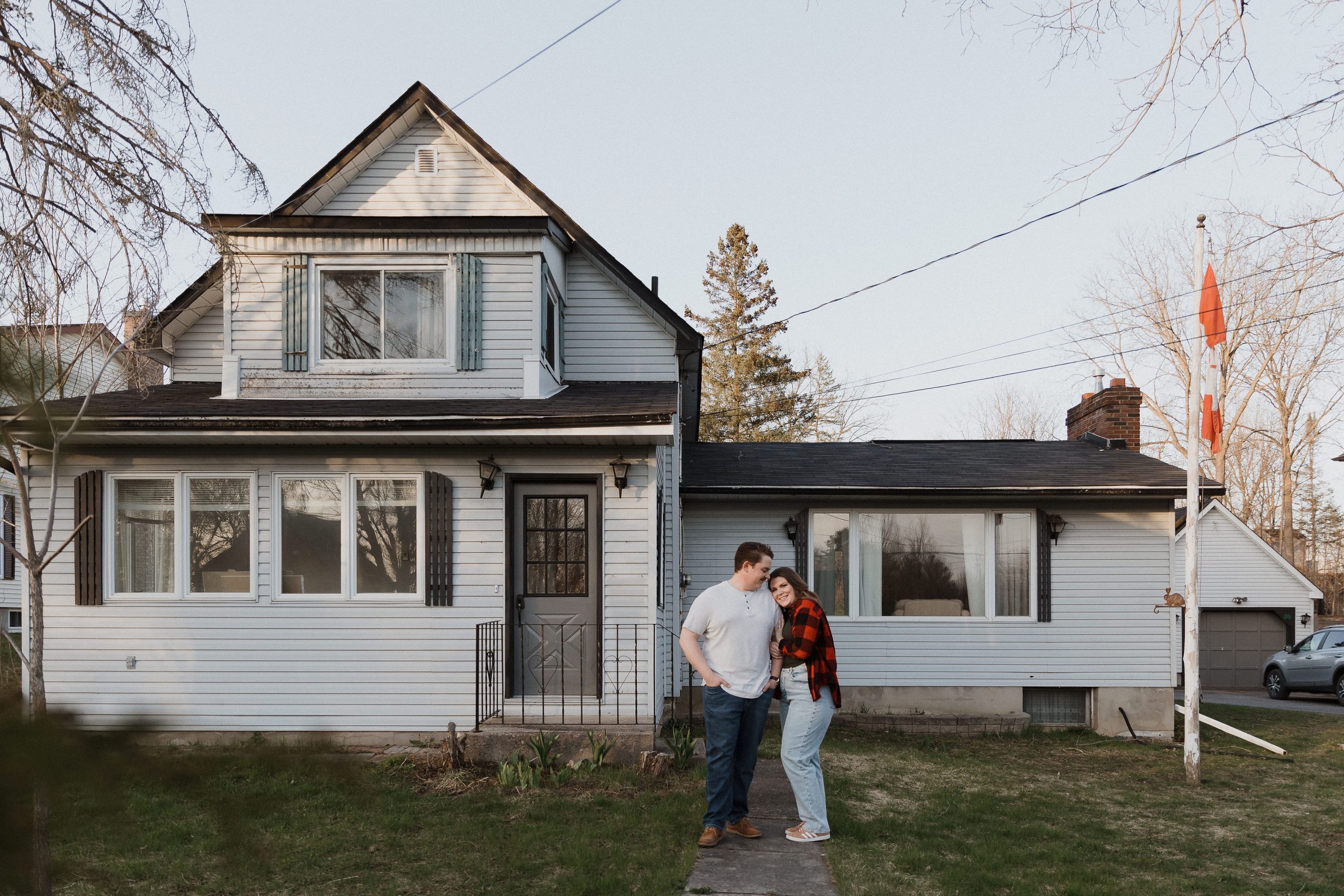 Couple in front of their old home in rural Ontario, in-home engagement photos by Sonia V Photography