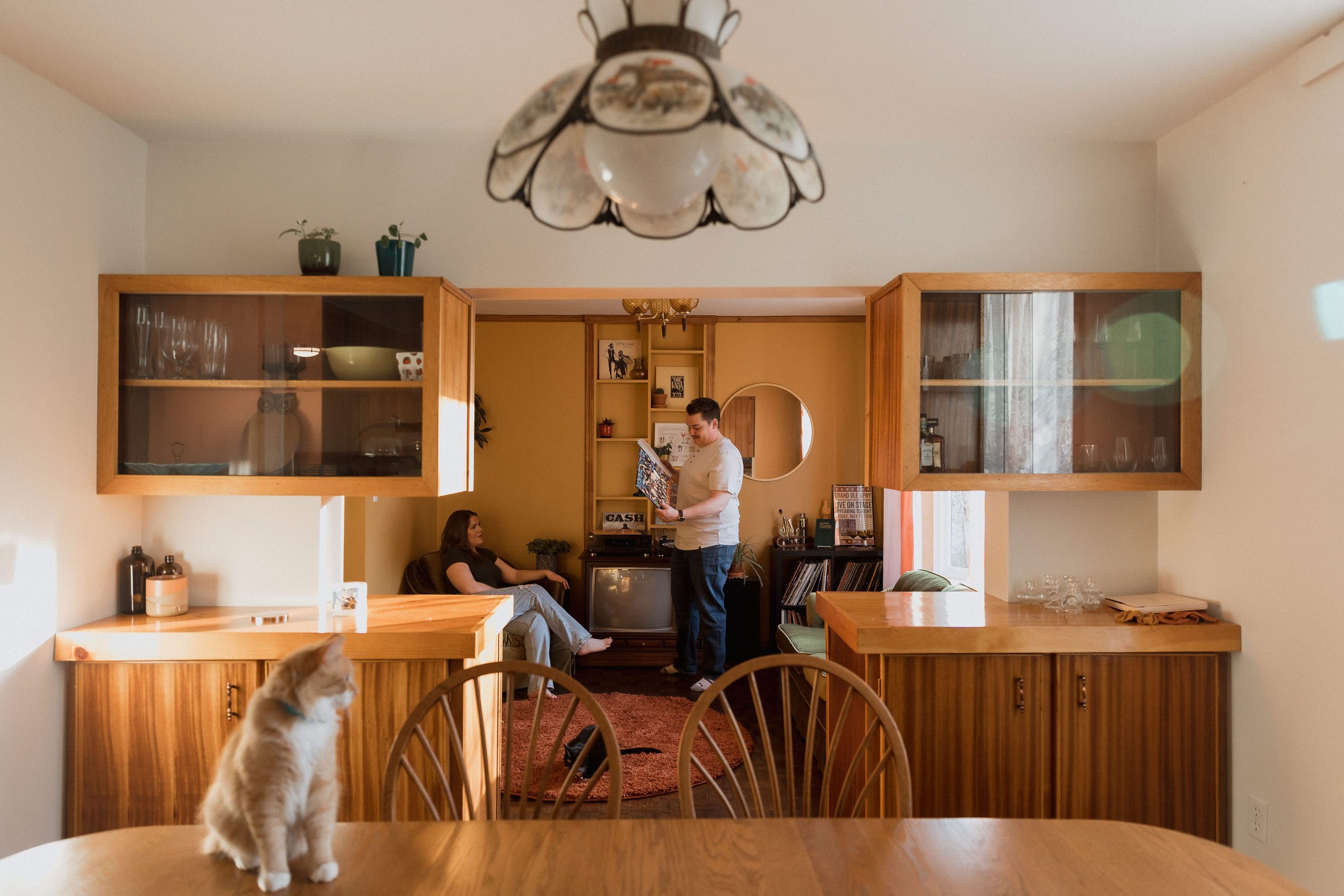 Orange living room retro style interiors in their home in rural Ontario, in-home engagement photos by Sonia V Photography