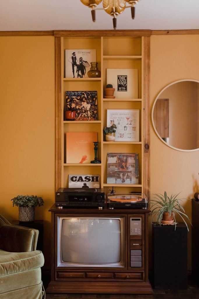 Orange living room retro style interiors in their home in rural Ontario, in-home engagement photos by Sonia V Photography